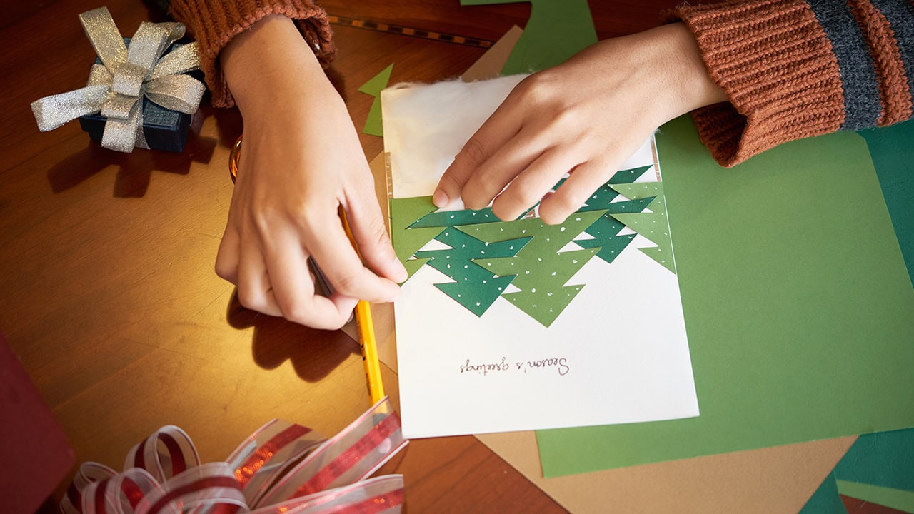 A resident making handmade Christmas greeting cards at a New Jersey holiday event. Image produced by More Jersey.