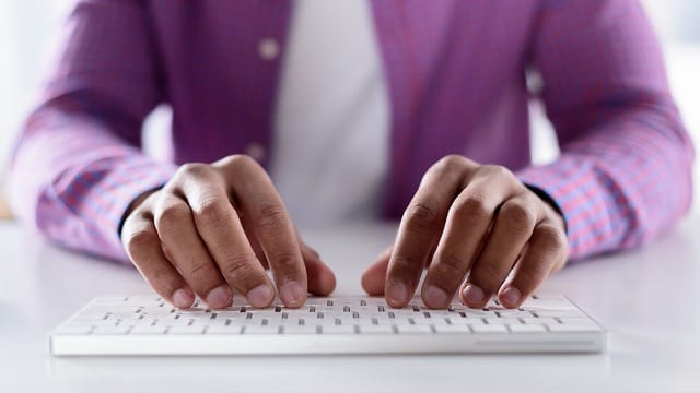 African-American male typing on wireless keyboard.