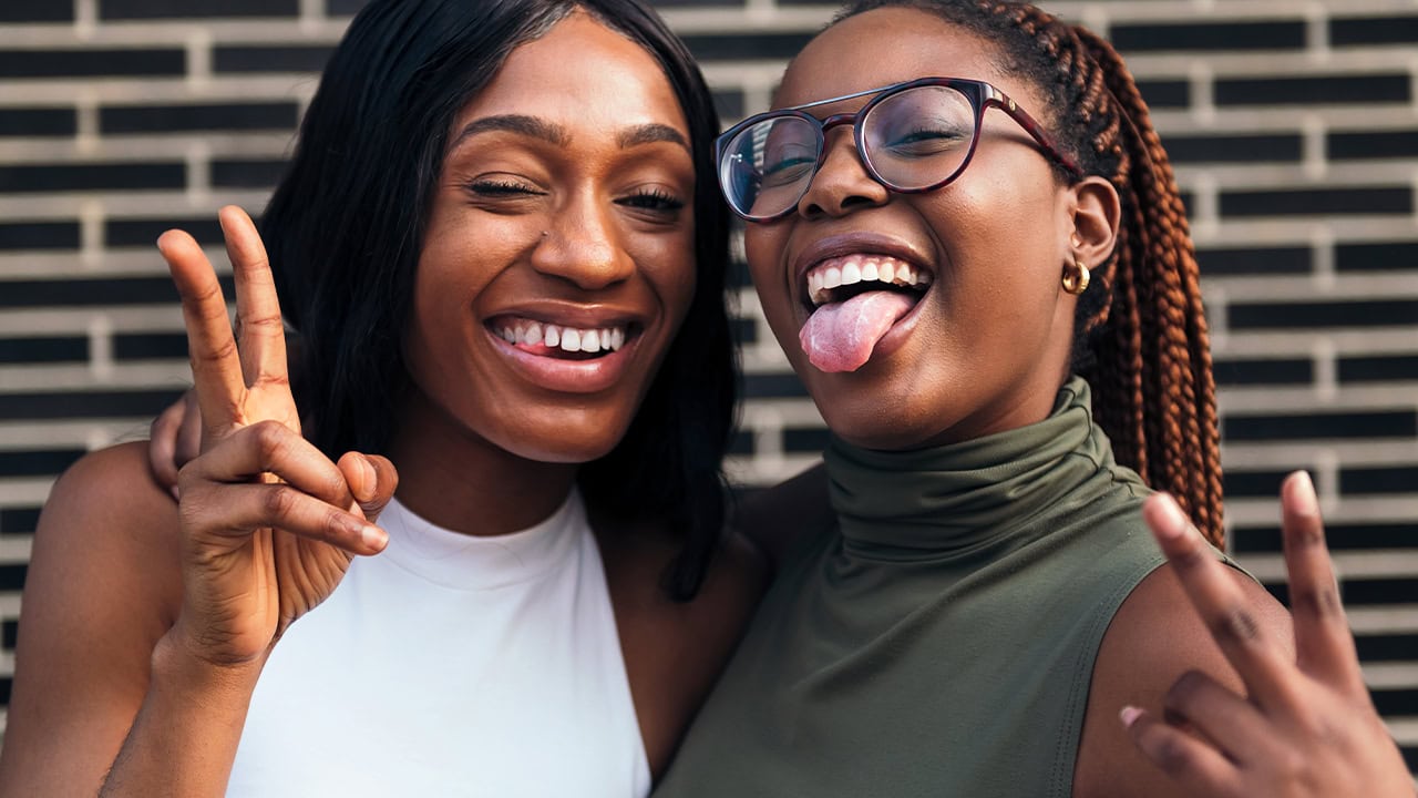 African American teenagers posing for camera displaying peace fingers. Image produced by More Jersey.