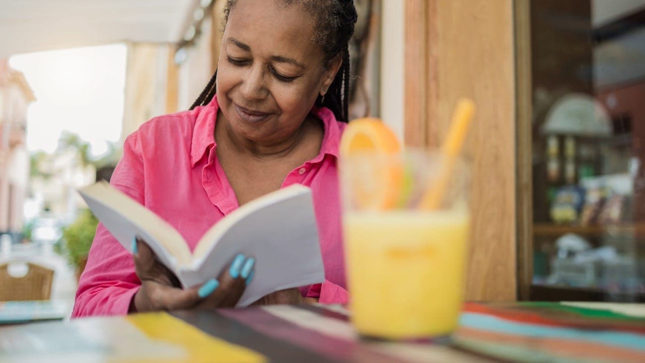 African-American woman reading a book during New Jersey brunch event.