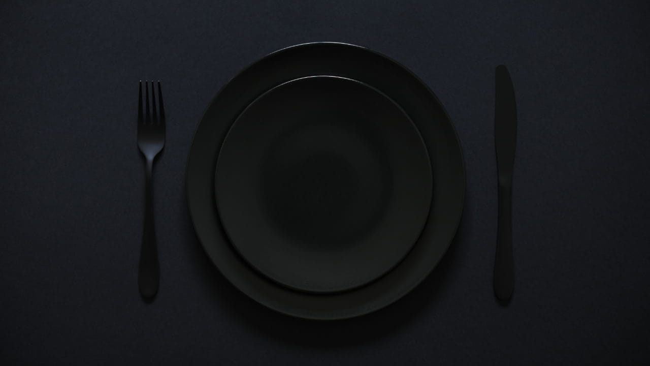 All black plate, utensils, and tablecloth table setting for a New Jersey dining event.