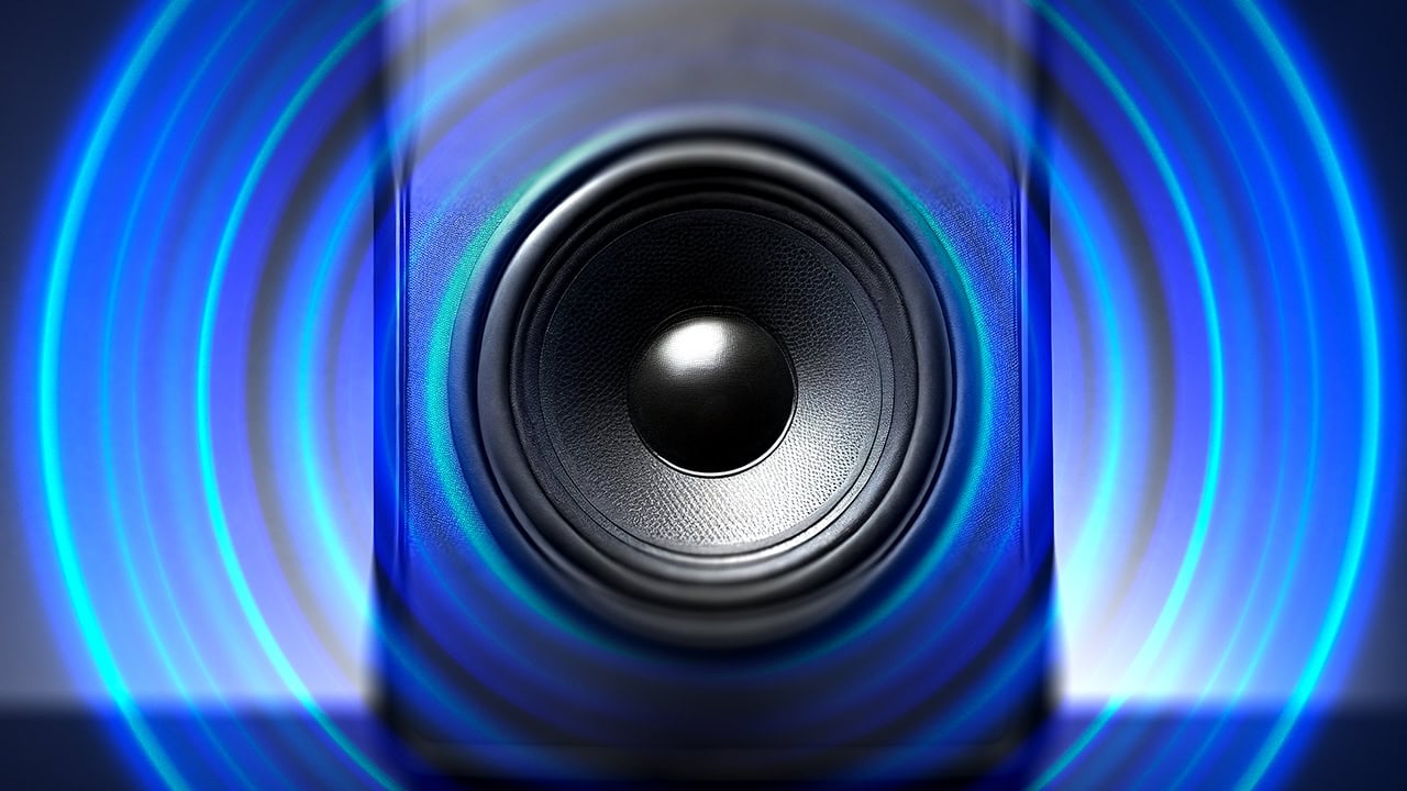 Audio speaker with oscillating blue sound waves. Image produced by More Jersey.