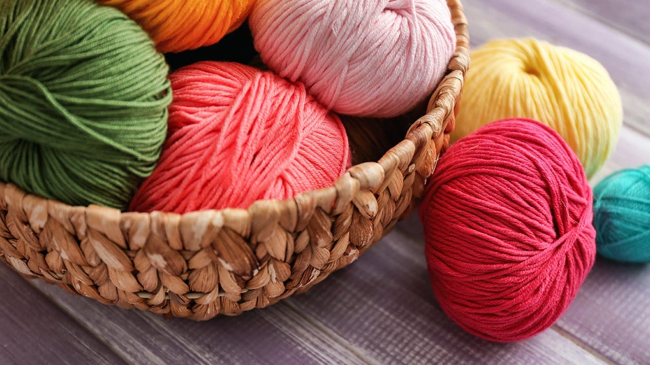 Basket of colorful yarn for knitting and crocheting.