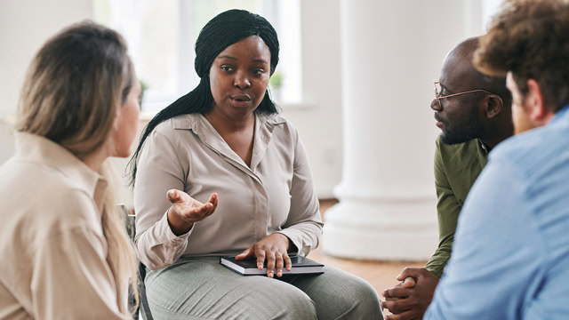 Black female psychotherapist giving advice to a patient during a support group session.