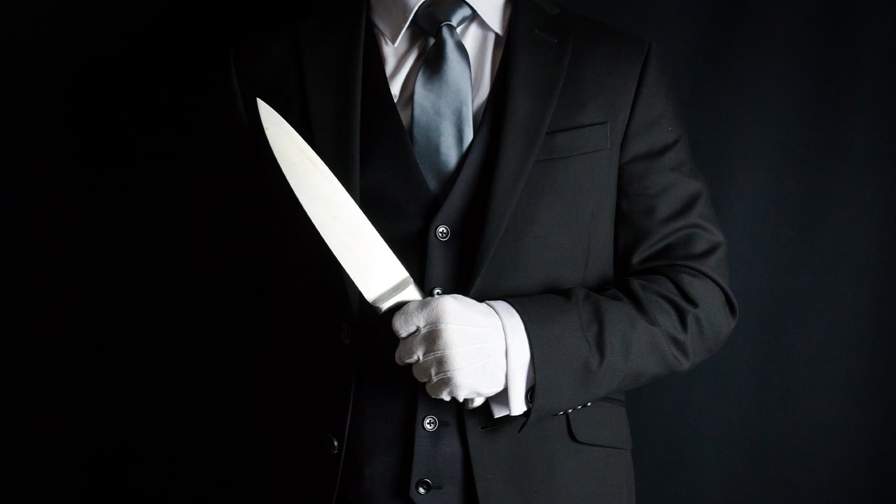 Butler with white gloves posing with large knife for New Jersey murder mystery event.