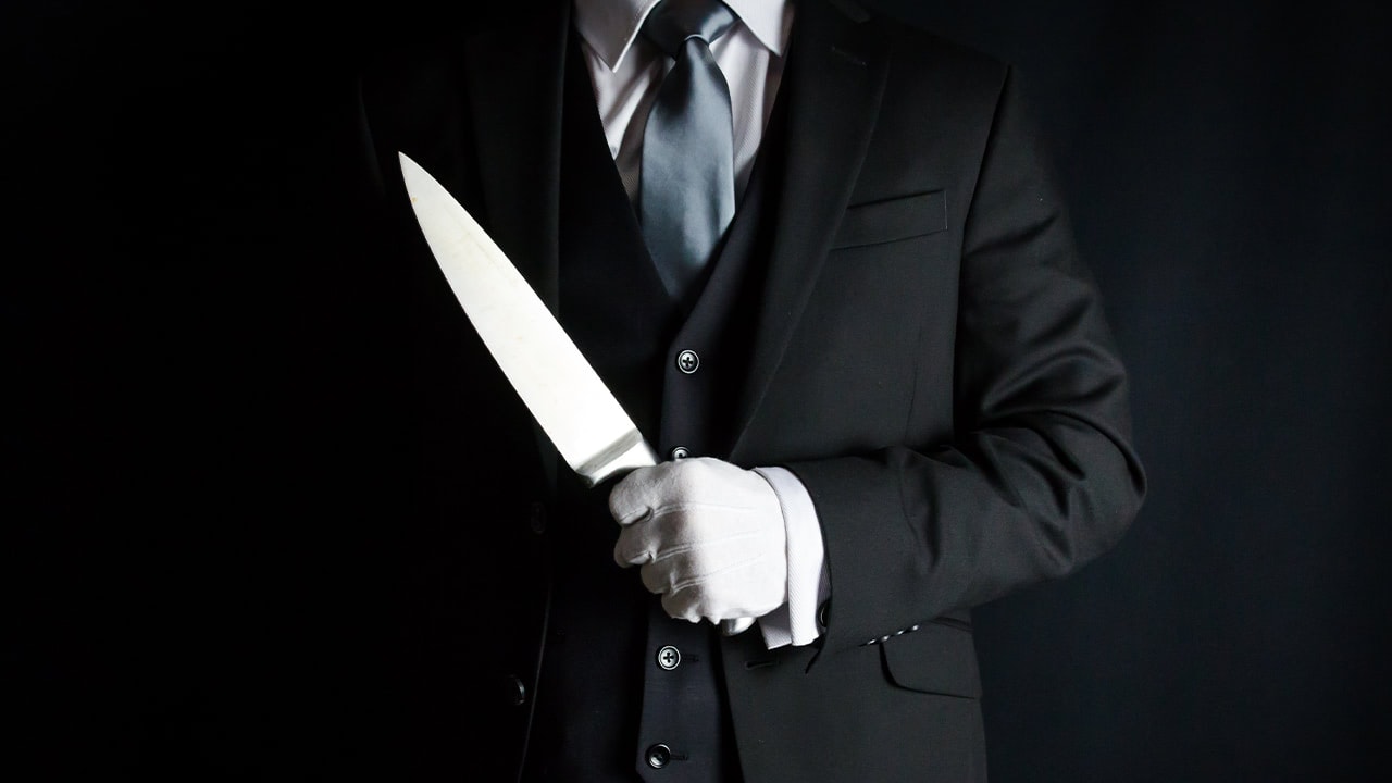 Butler with white gloves posing with large knife for New Jersey murder mystery event. Image produced by More Jersey.