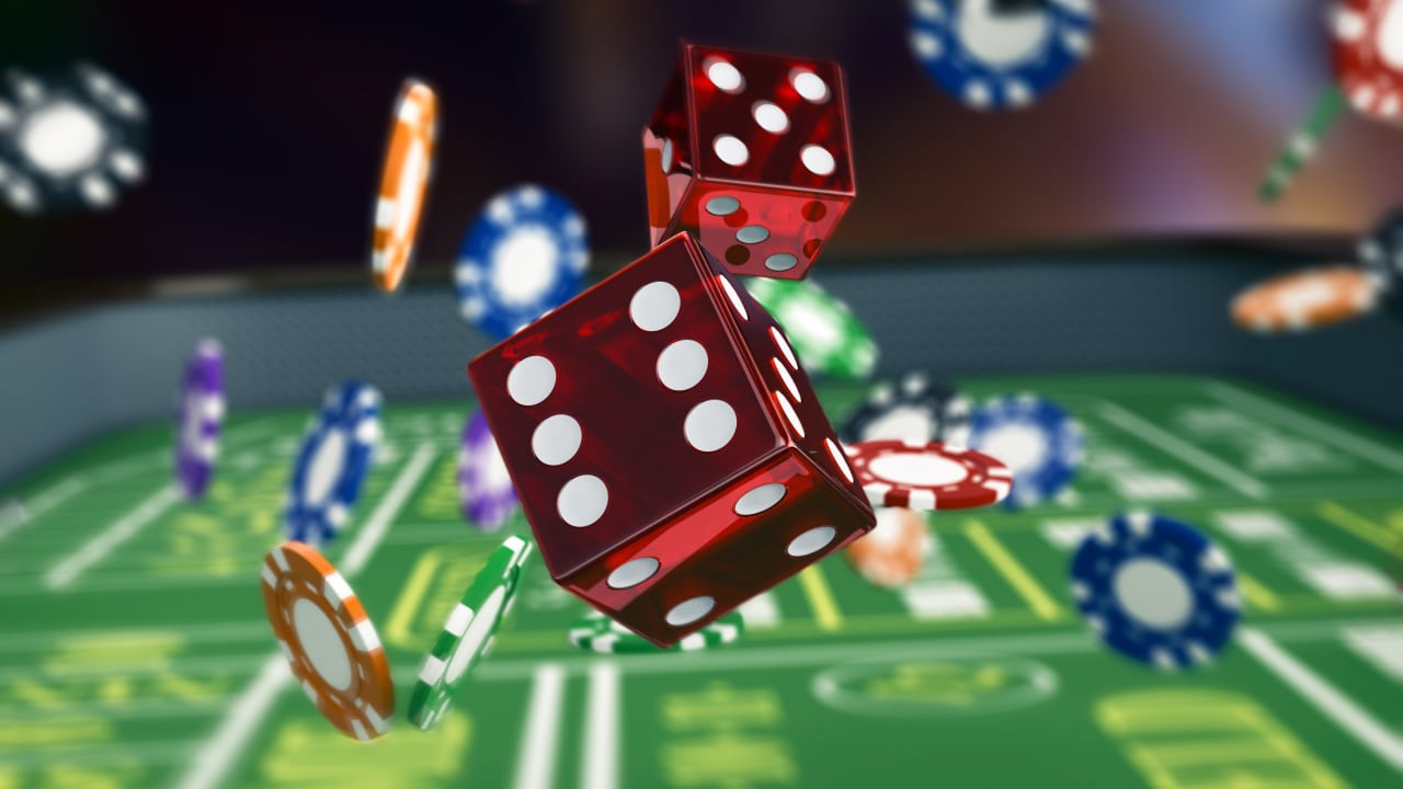 Casino dice and chips falling onto game table.