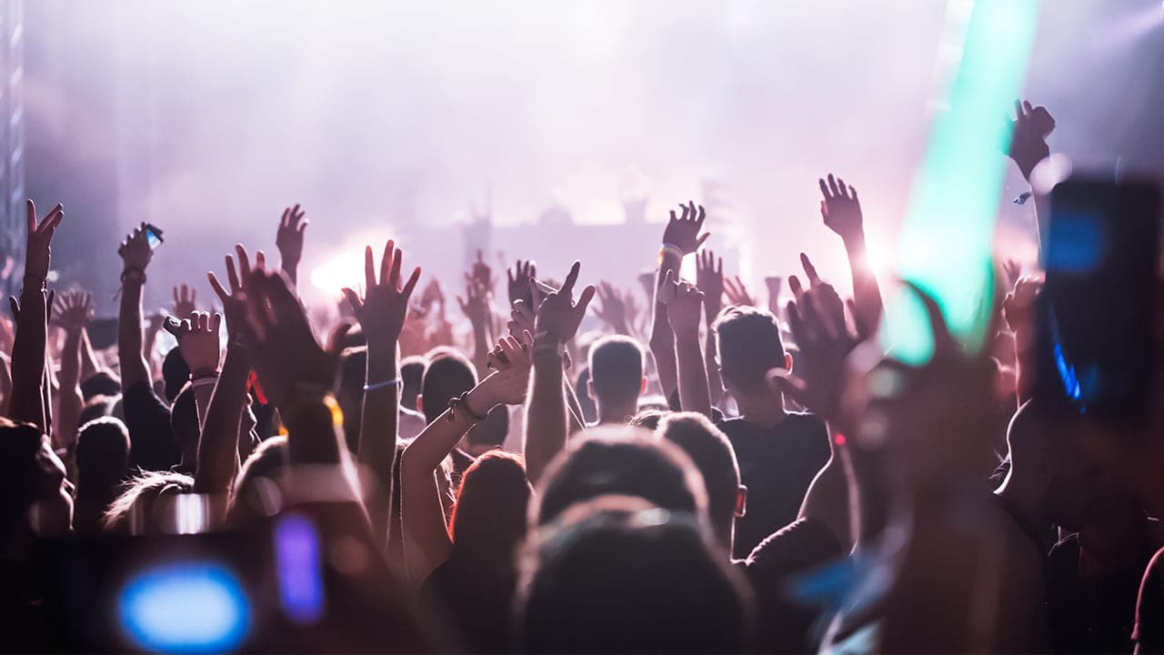 Cheering crowd with hands raised at a concert in New Jersey.