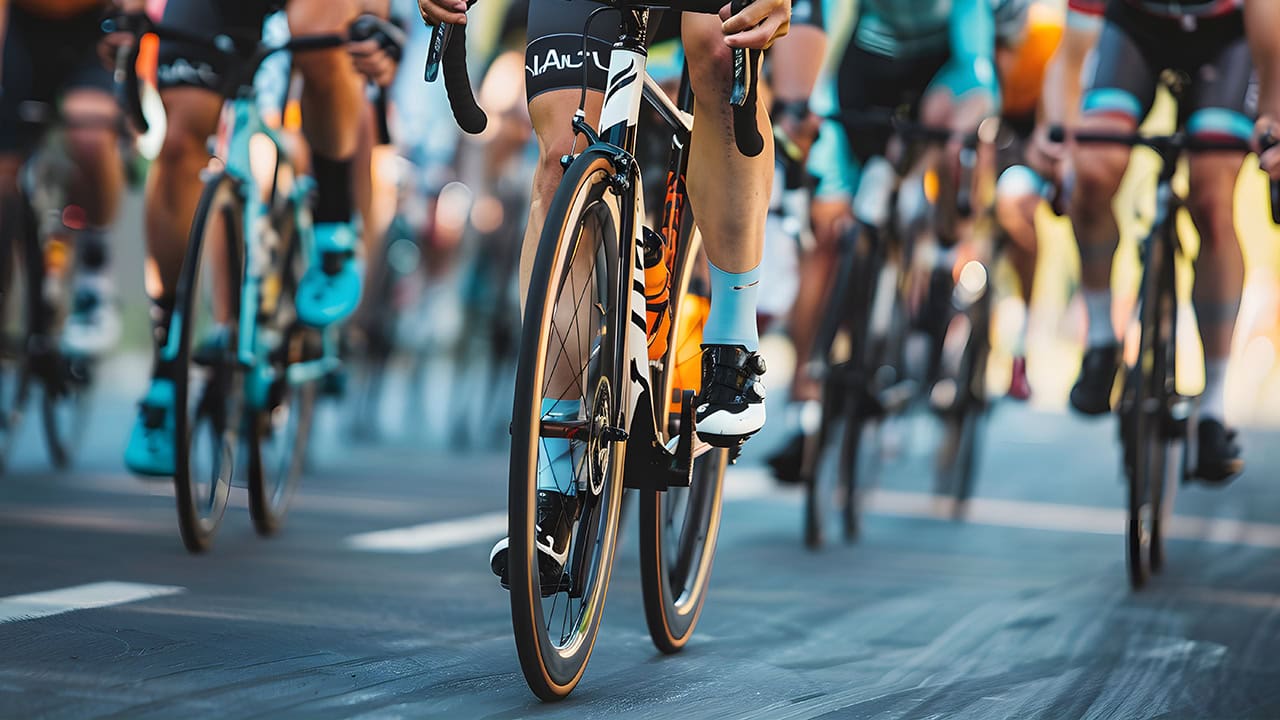 Close-up of multiple cyclists participating in cycling race. Image produced by More Jersey.