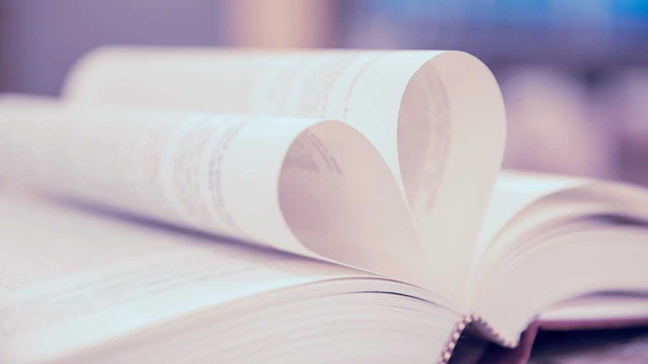 Close-up photo of a book with pages forming a heart shape on the table at New Jersey library.