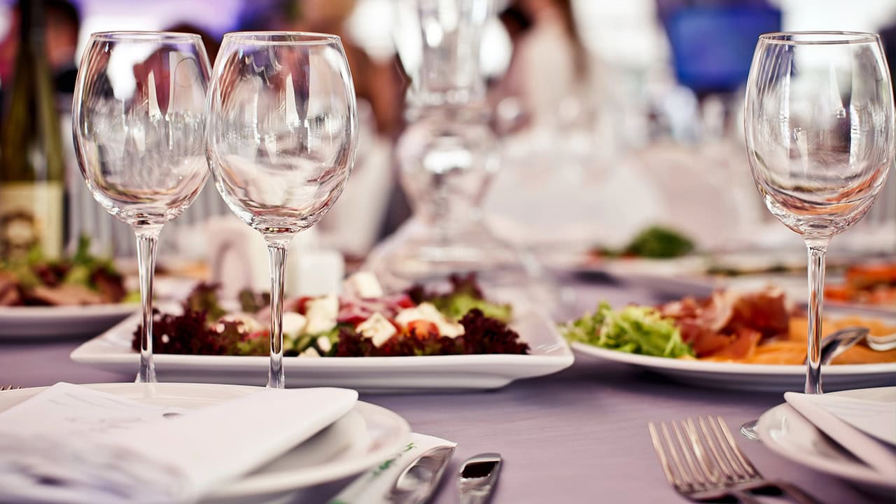 Close-up of empty glasses, food, and silverware on restaurant table. Image produced by More Jersey.