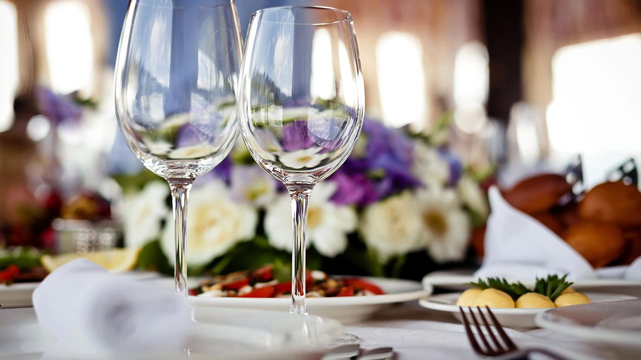 Close-up of empty glasses, food, and silverware on restaurant table. Image produced by More Jersey.