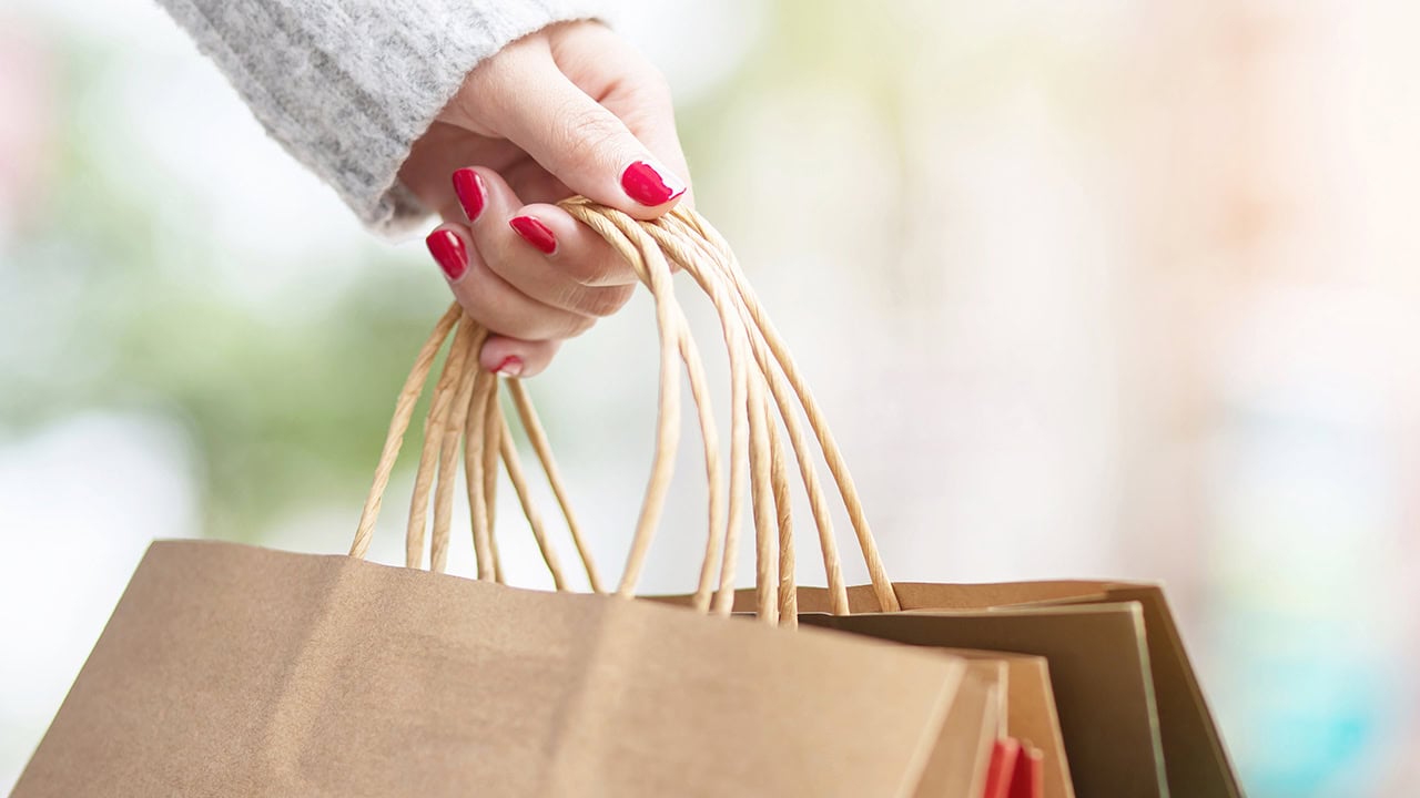 Close-up of woman holding multiple shopping bags. Image produced by More Jersey.