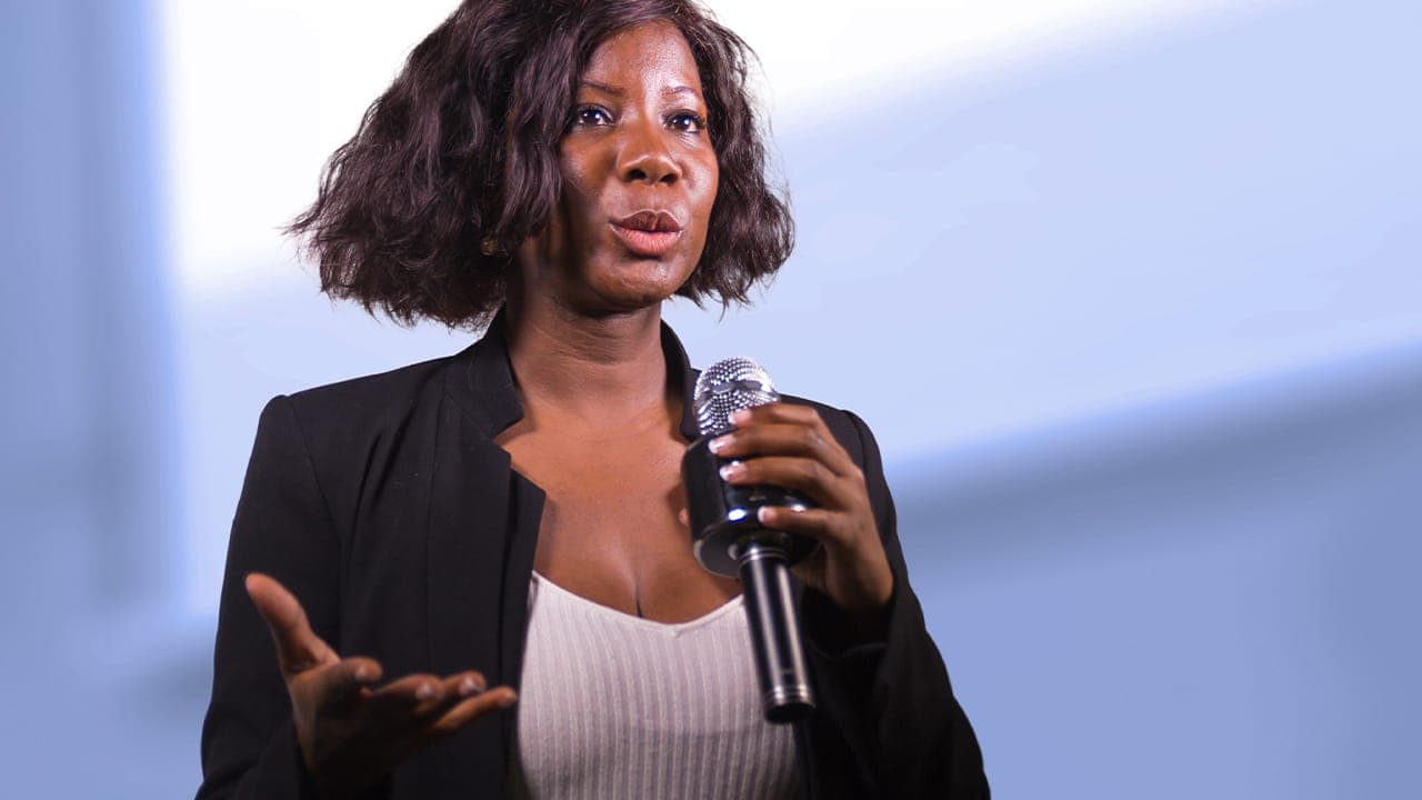 Confident black female presenter speaking at New Jersey event.