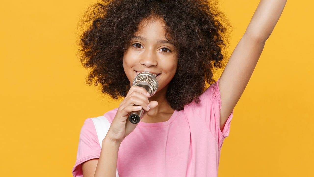 Cute African-American young girl speaking on the microphone.