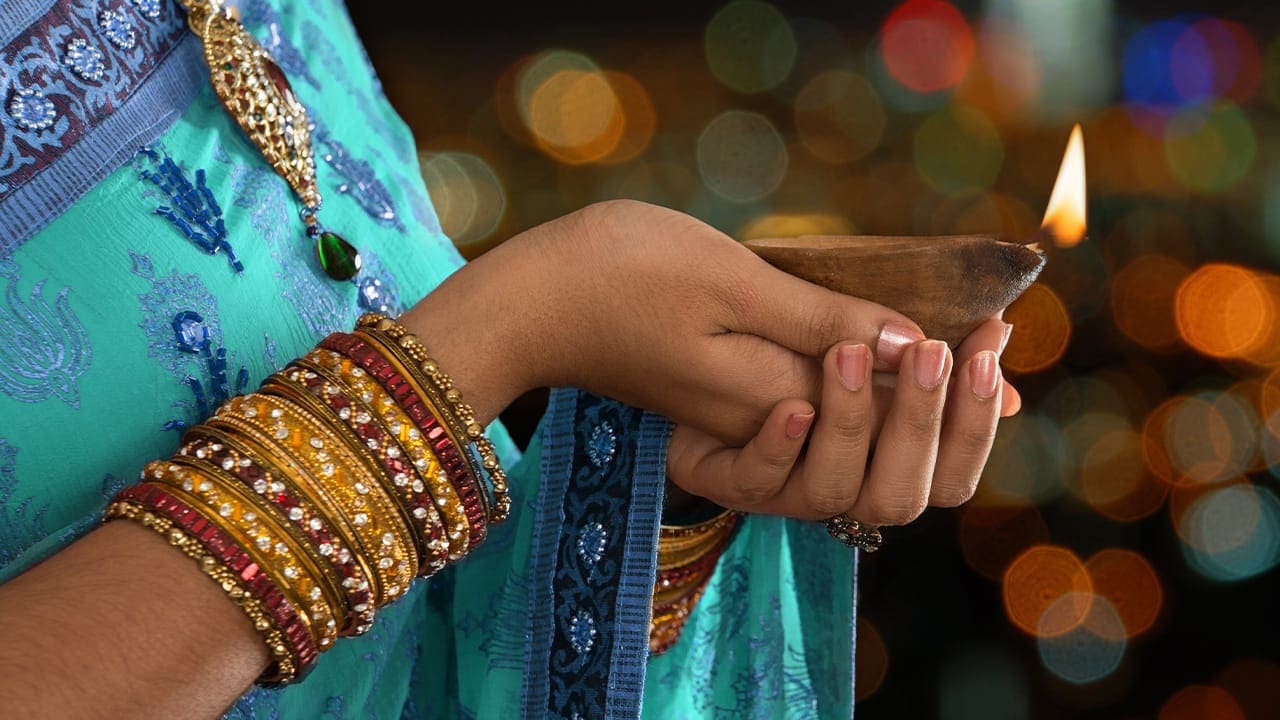 Desi female holding New Jersey Diwali event light.