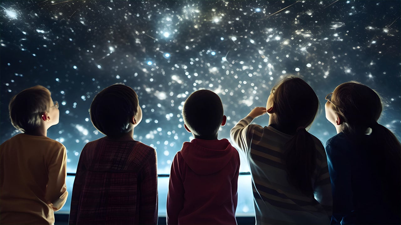 Diverse group of children gazing up at stars at New Jersey planetarium.