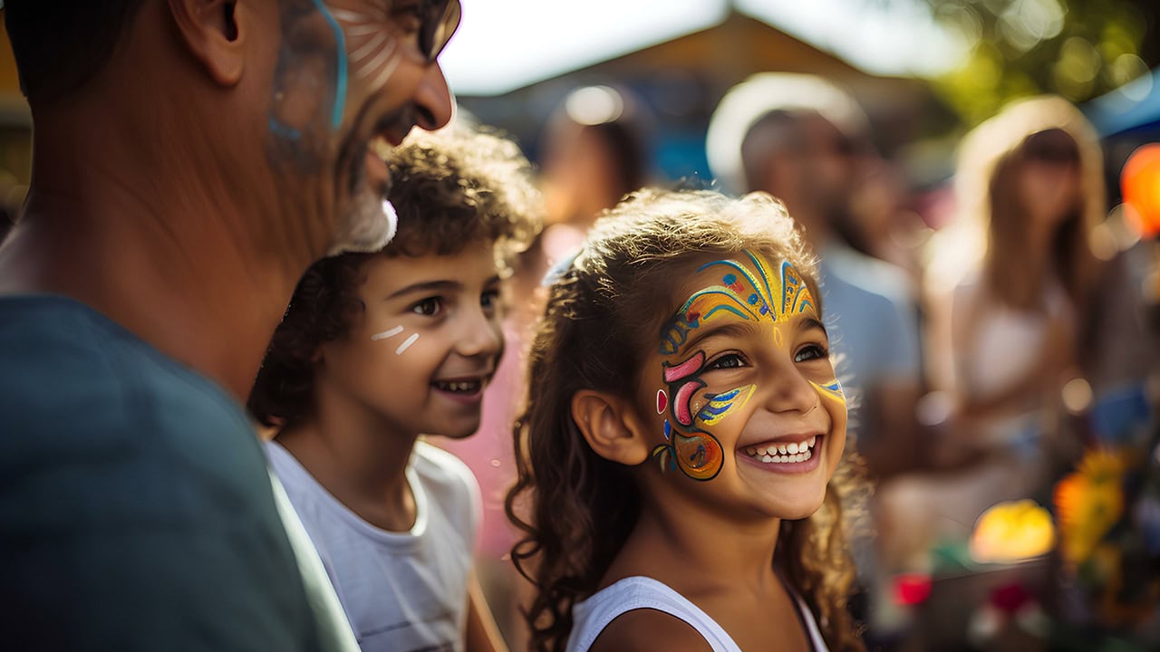 Father with children wear face paint at New Jersey festival.