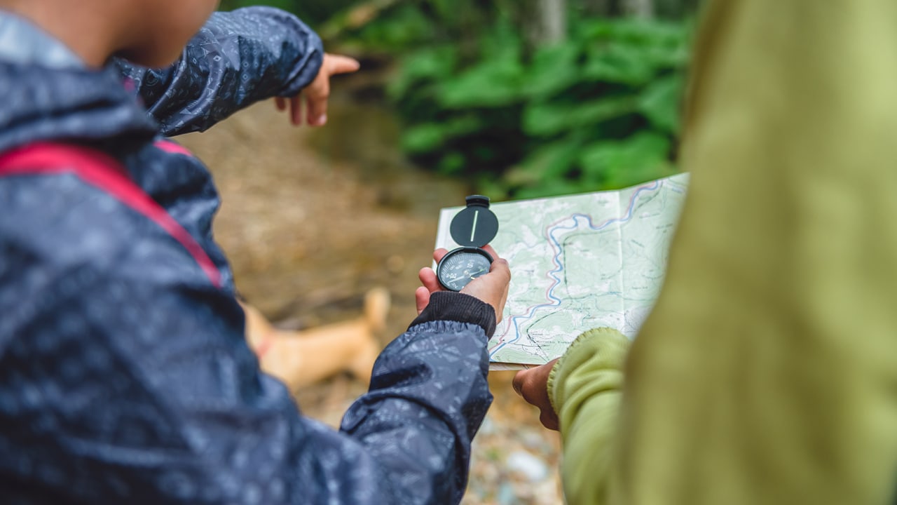 Girl using compass for hiking activity.