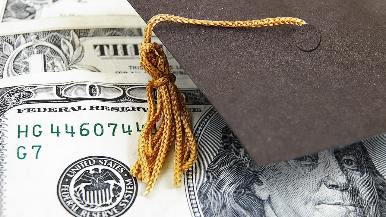Graduation cap on money representing NJ college student loan debt.