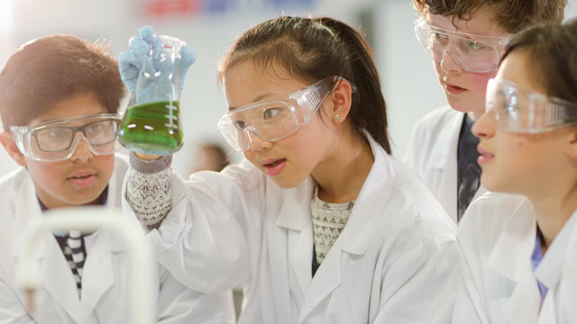 Group of diverse students conducting a scientific experiment in a laboratory classroom.