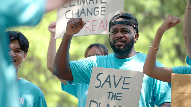 Group of diverse volunteers holding banners to fight for climate change and environmental justice.