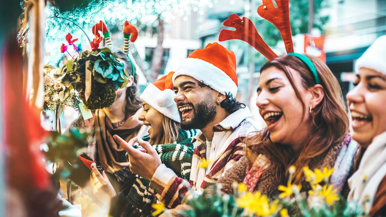 Group of friends looking at Christmas items at New Jersey holiday marketplace fair. Image produced by More Jersey.