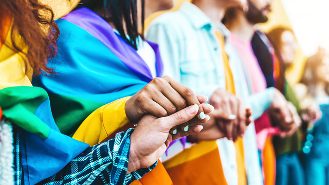 Group of New Jersey queer residents holding hands in unity.