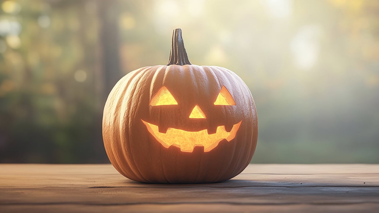 Halloween Jack-o'-lantern pumpkin on wooden table. Image produced by More Jersey.