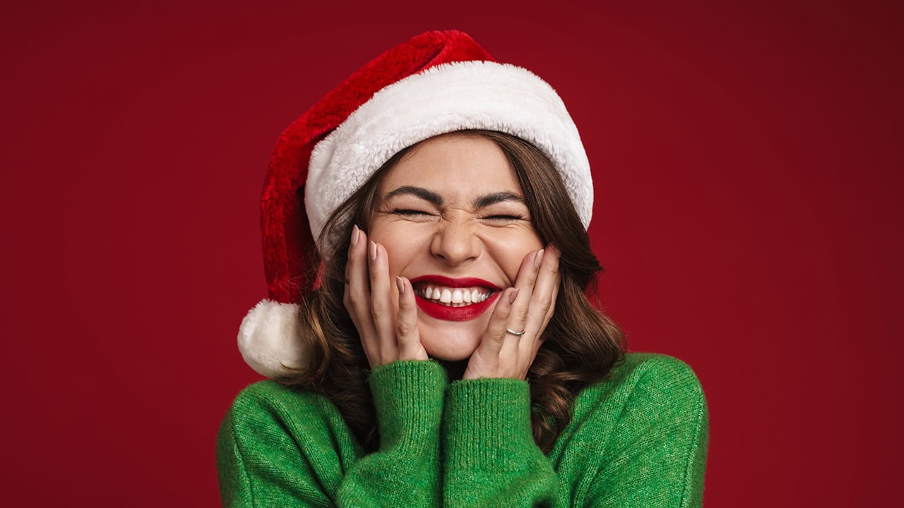 Happy smiling woman wearing Christmas Santa Claus hat. Image produced by More Jersey.