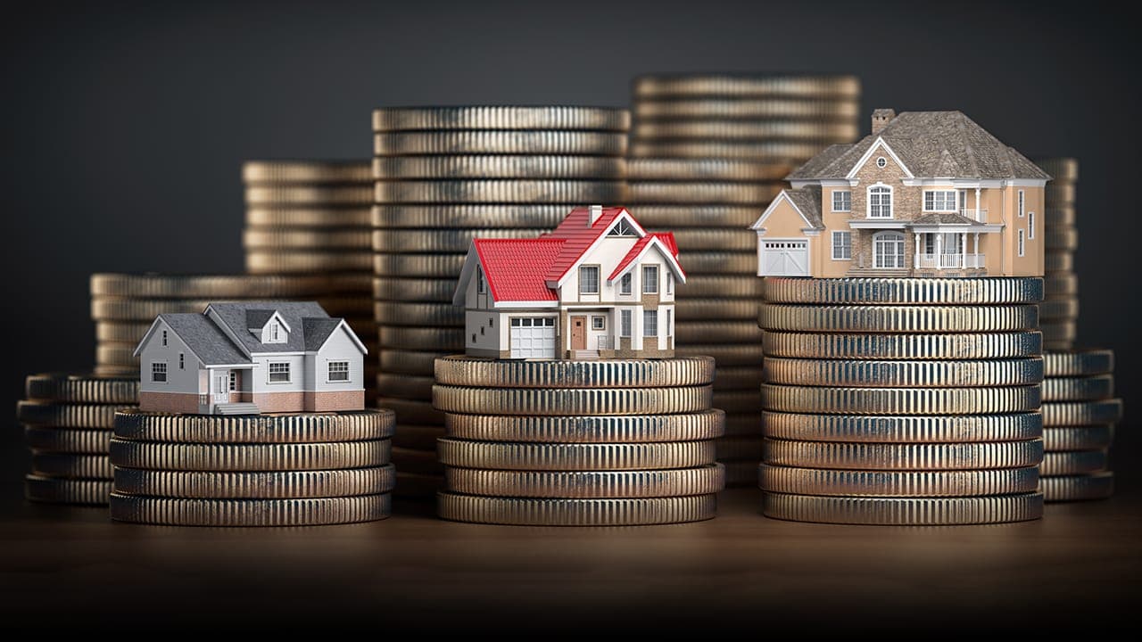 House miniatures placed on top of stacks of coins representing New Jersey real estate investment. Image produced by More Jersey.