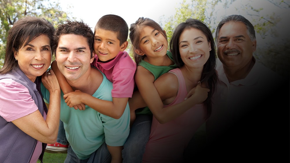 Latino family taking a group photo at an outdoor New Jersey Hispanic Heritage Month event.