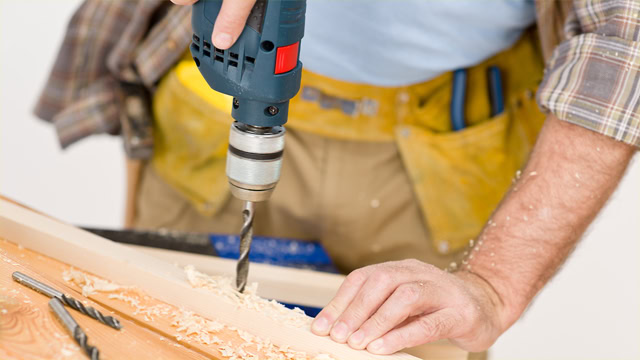 Local New Jersey handyman drilling wood for home improvement project.