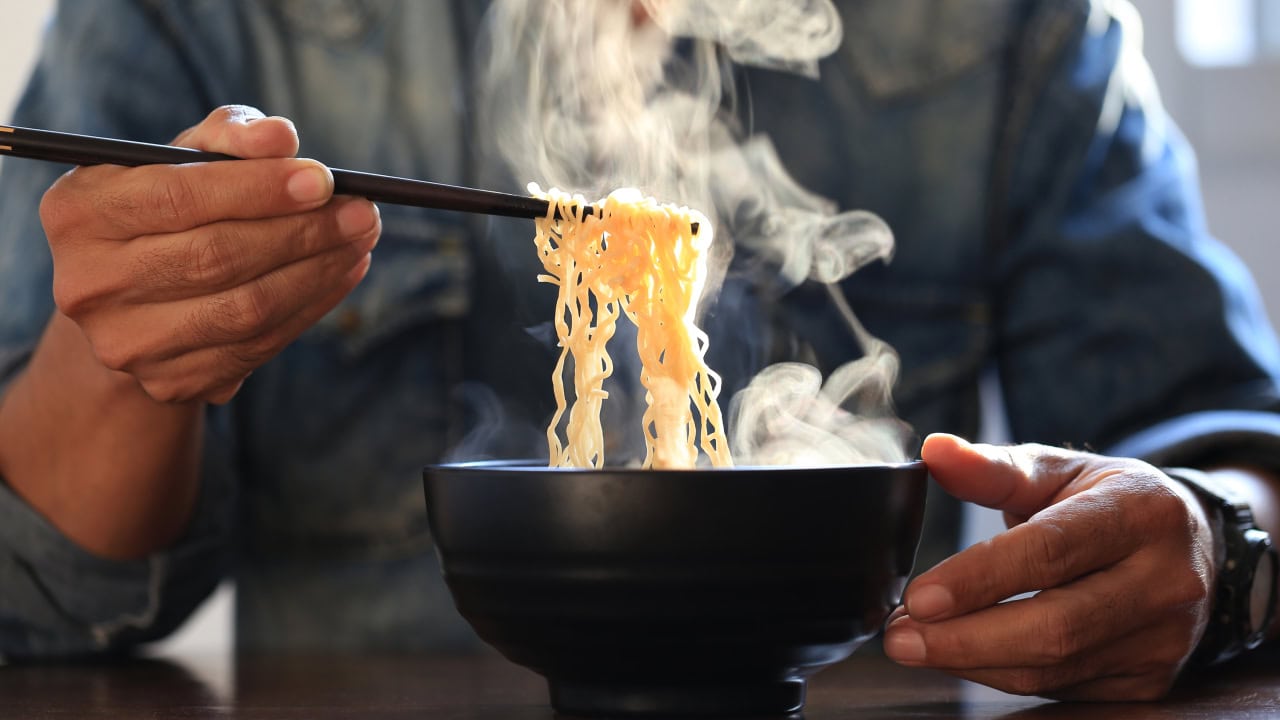 New Jersey resident eating ramen noodles with chopsticks. Image produced by More Jersey.