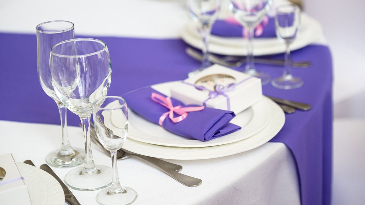 New Jersey banquet hall table decorated with crystal silverware and purple table cloths. 