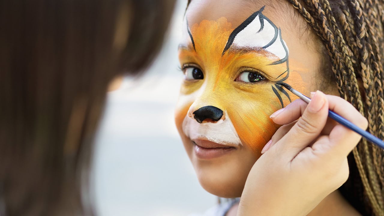 African-American girl receiving face painting at New Jersey fair.