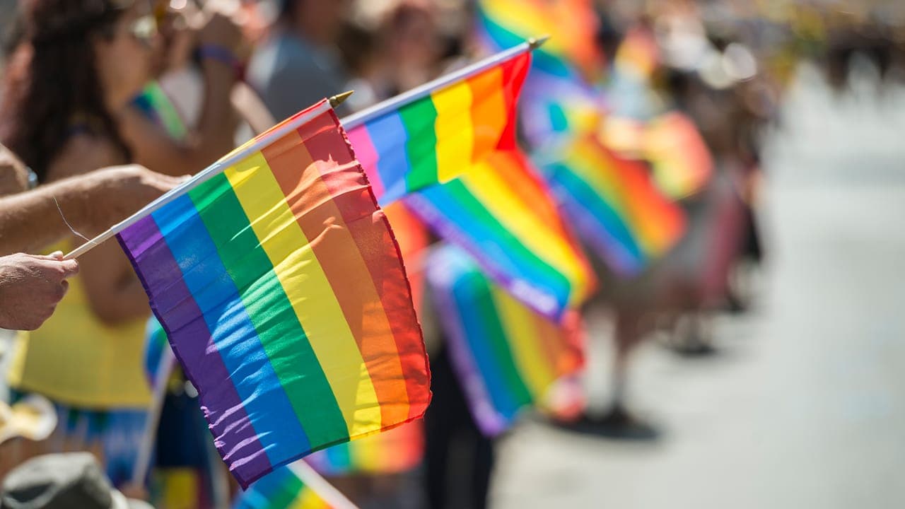 New Jersey residents waving rainbow flags at Pride Month celebration.