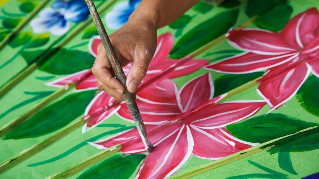 New Jersey resident hand painting flowers on an umbrella at an umbrella decorating event.
