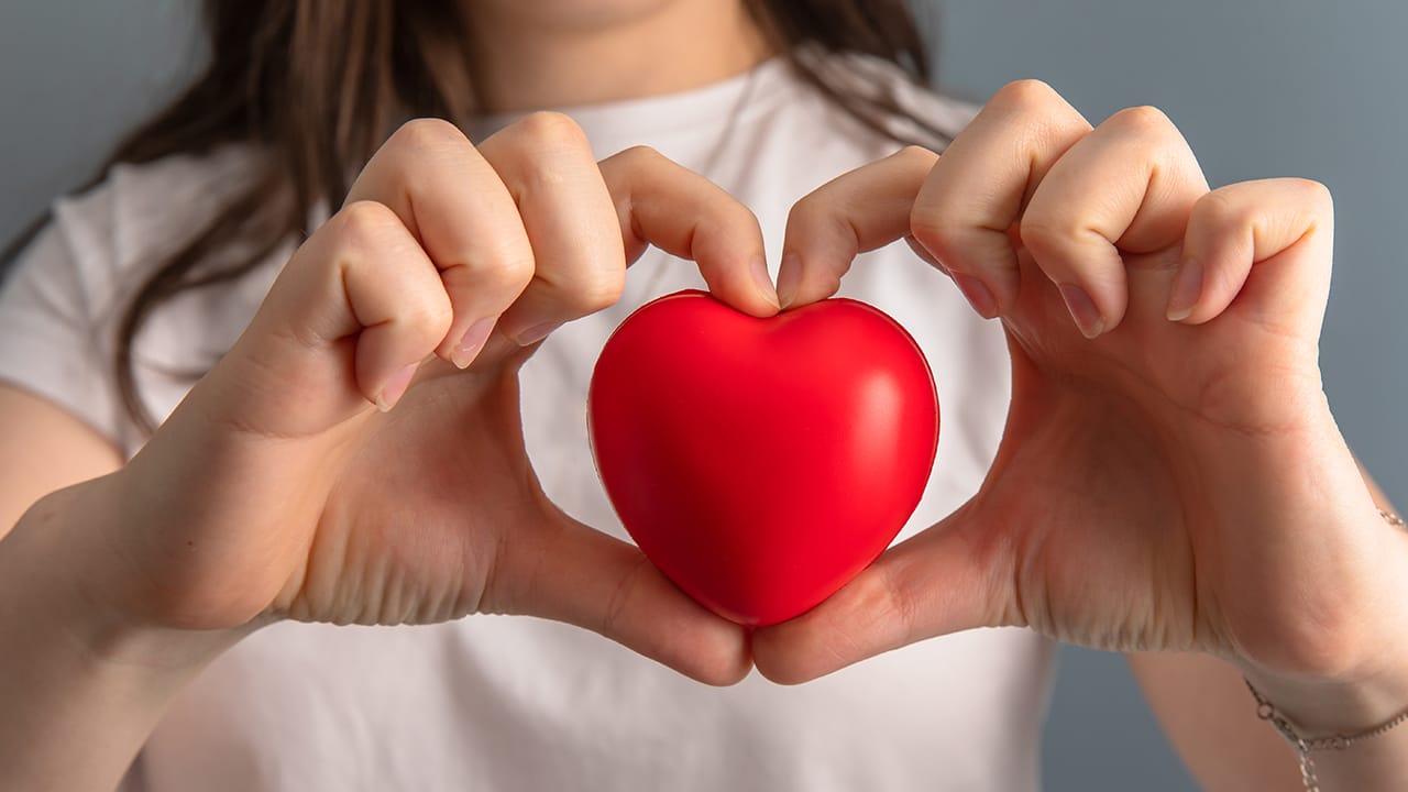 New Jersey resident holding heart shape depicting caring and compassion. Image produced by More Jersey.