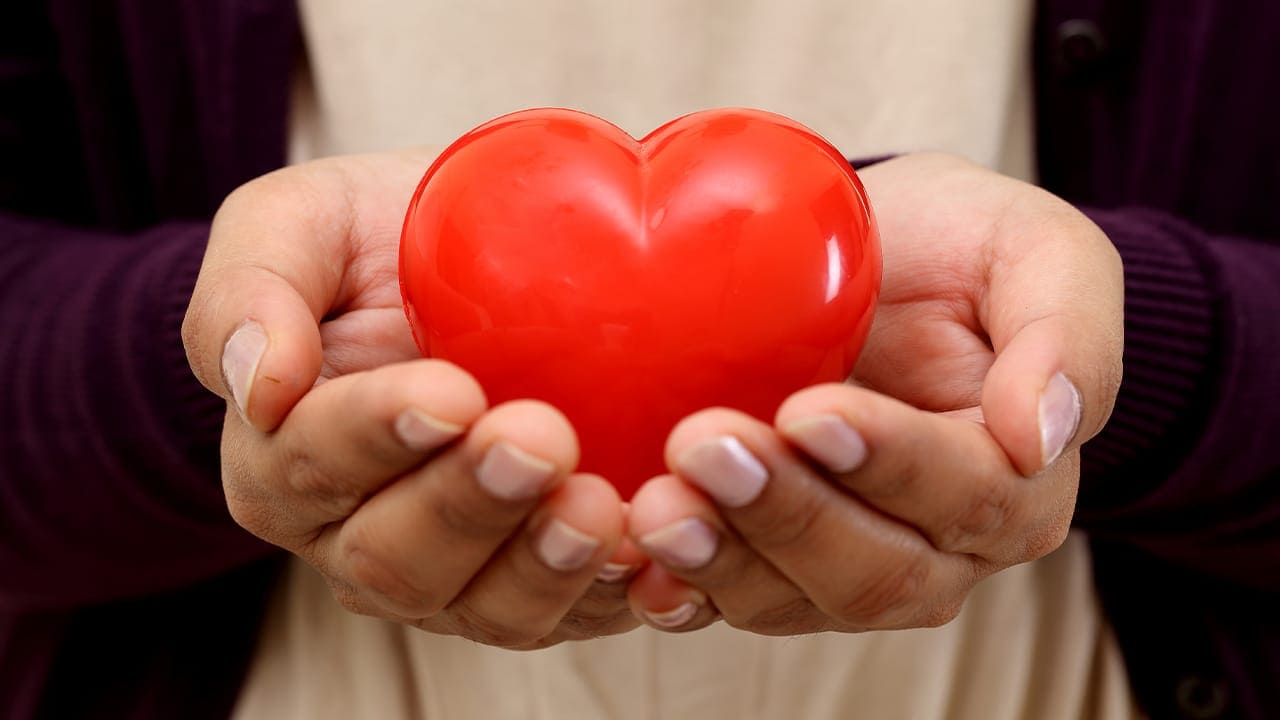 NJ resident holding heart shape in the hands. Image produced by More Jersey.