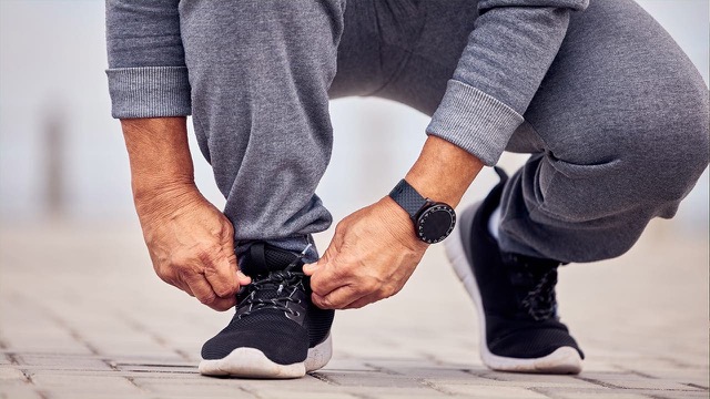 New Jersey resident lacing sneakers in preparation of outdoor exercise.