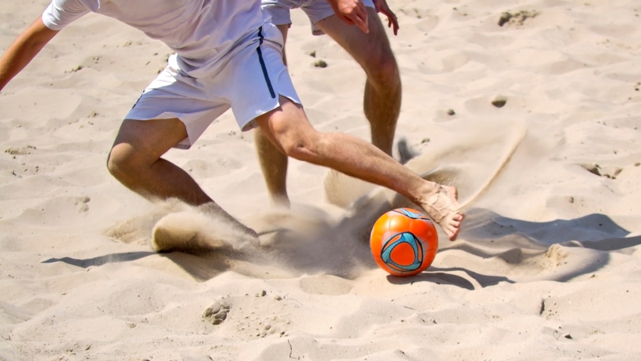 Players battling for the ball during New Jersey beach soccer tournament.