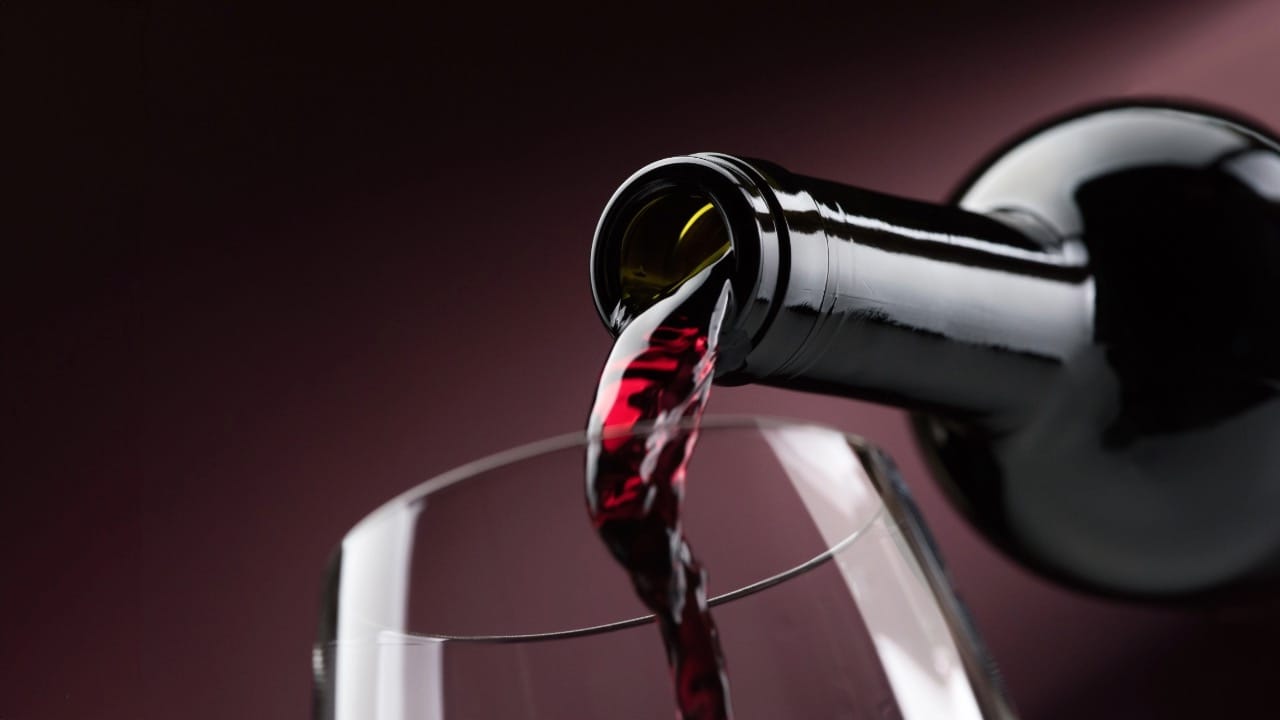 Pouring red wine into a wineglass. Image produced by More Jersey.