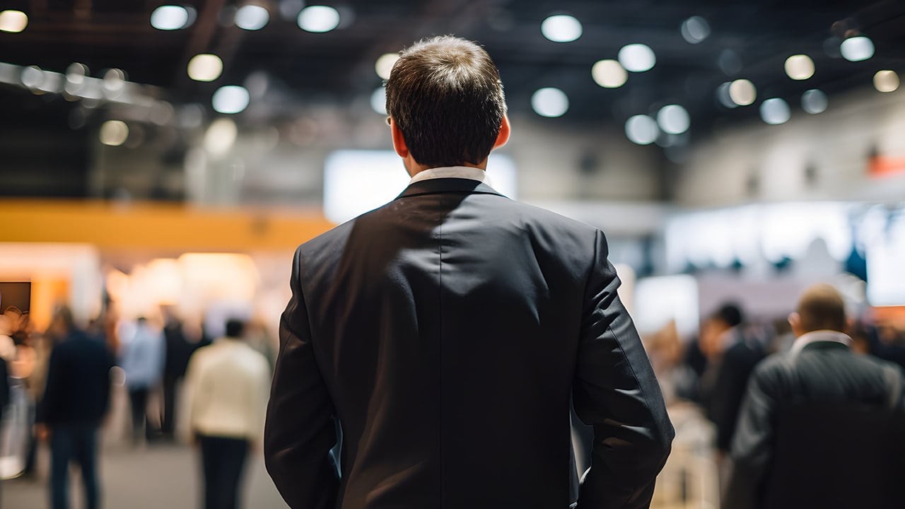 Rear view of a man wearing a business suit at a New Jersey expo event.