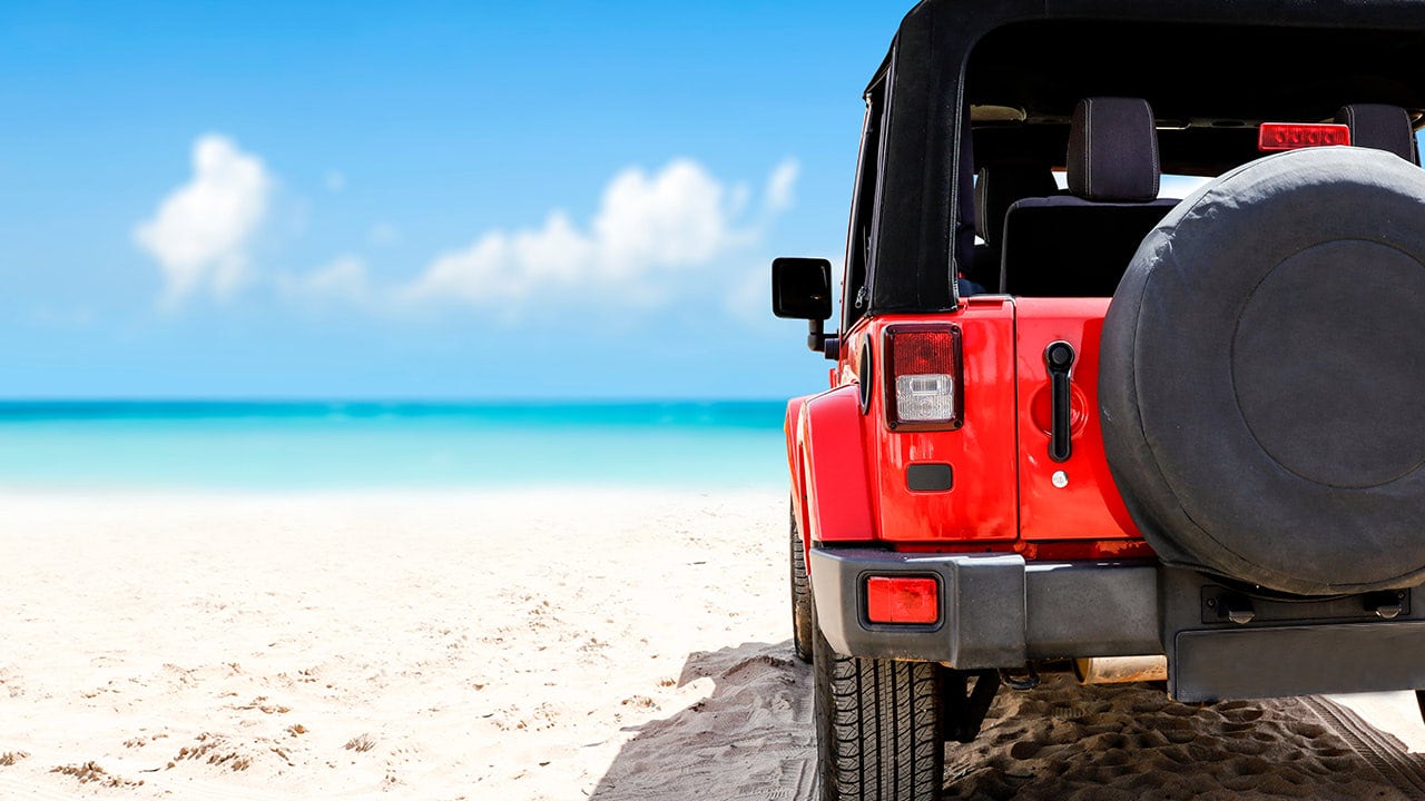 Red Jeep parked on the beach for New Jersey Jeep Beach Festival.