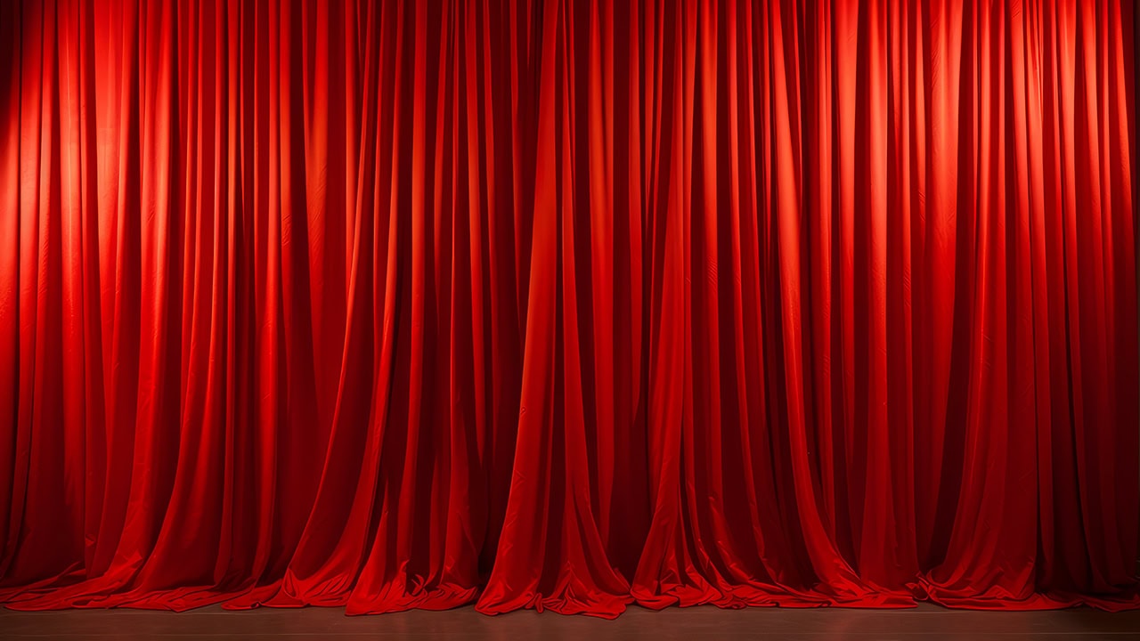 Red theatrical curtain closed on stage. Image produced by More Jersey.