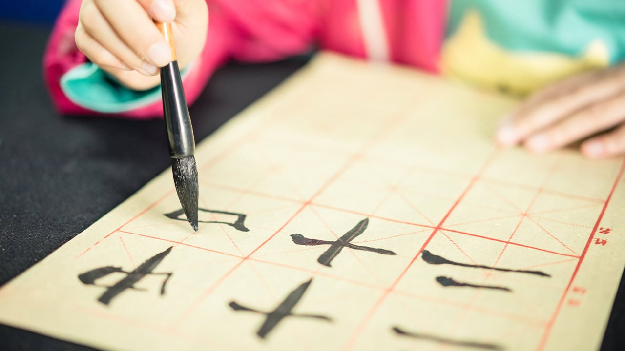 Resident learning to write Chinese characters in calligraphy class.