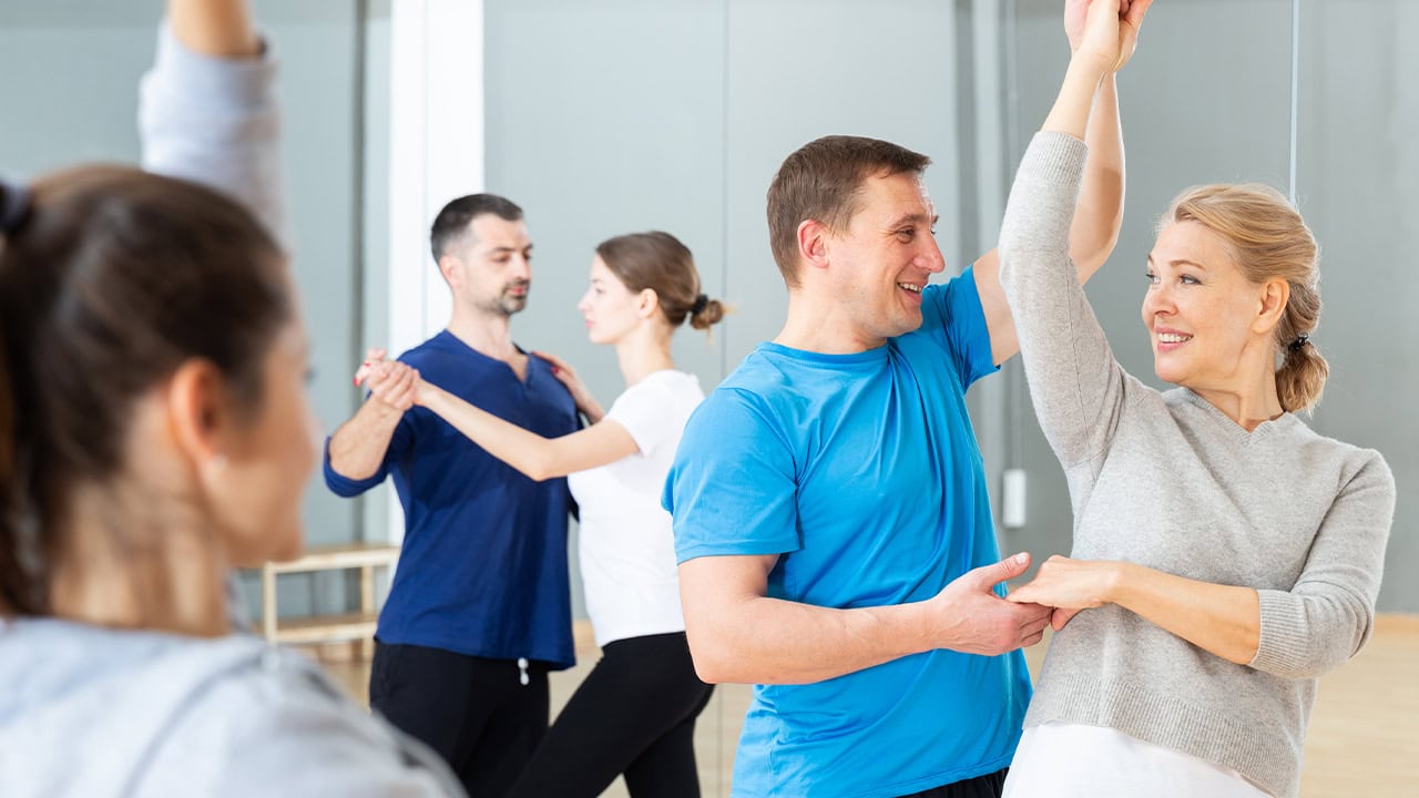 Residents practicing bachata dance moves in pairs during group dance class. Image produced by More Jersey.