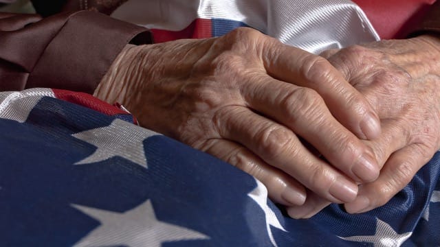 Senior New Jersey veteran holding United States flag.