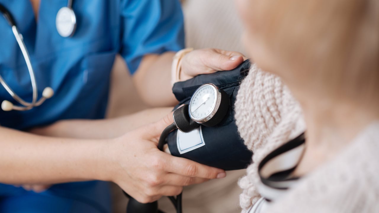 Senior woman receiving blood pressure screening at New Jersey health fair. Image produced by More Jersey.